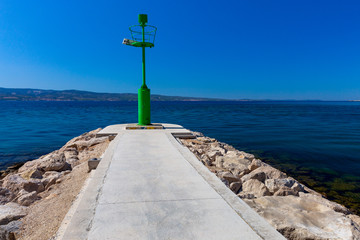Omis. Green lighthouse on a breakwater.