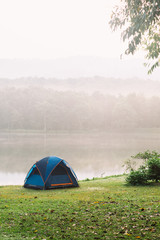 Camping tent by a lake with mist at sunrise Jedkod-Pongkonsao Natural Study in Saraburi Thailand