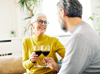 senior couple drinking wine at home