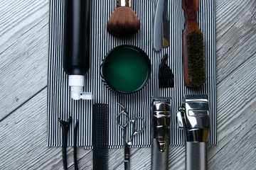 Flat lay from hairdressing accessories including: haircuts, scissors, combs, gels for styling and...