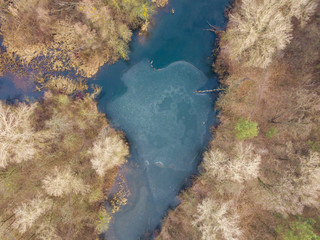Aerial drone view. A lake covered with a thin crust of ice in the shape of a heart