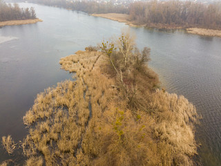 Aerial drone view. A small island on the river in Kiev in late autumn. Dry grass envelops the...
