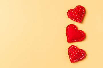 Composition of textile red hearts on colorful background with empty space for your design. Top view of St. Valentine's day concept