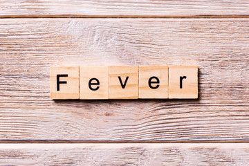 fever word written on wood block. fever text on wooden table for your desing, coronavirus concept top view