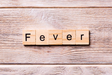 fever word written on wood block. fever text on wooden table for your desing, coronavirus concept...