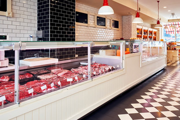 Selection of raw fresh veal meat in the refrigerated display of a butcher shop
