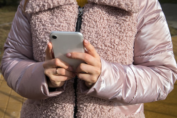 Girl pointing her finger on the smartphone screen during the day.Phone in women's hands.
