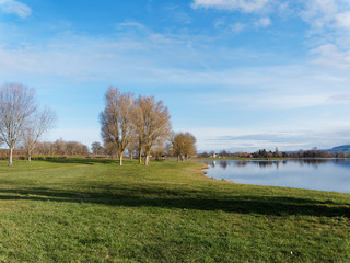 Le lac de Lapeyrouse dans le Puy-de-Dôme entouré de prairie verdoyante et arborée 