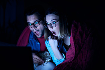 Obraz na płótnie Canvas couple movie night horror laptop popcorn love watching entertainment