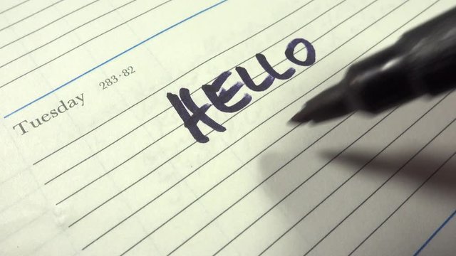 Writing the greeting message Hello World in a diary.