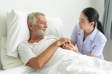 Obraz premium Young nurse take care senior man on a bed, A nurse checking sernior man, Senior man happniess and smiling with nurse, Health care concept