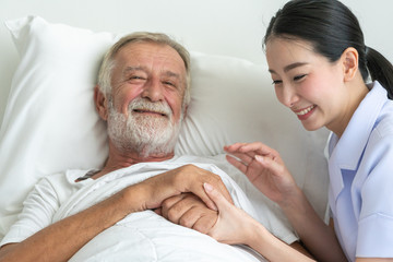 Young nurse take care senior man on a bed, A nurse checking sernior man, Senior man happniess and smiling with nurse, Health care concept
