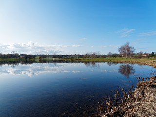 Les eaux calmes du lac de Lapeyrouse dans le Puy-de-Dôme sous un ciel bleu d'hiver