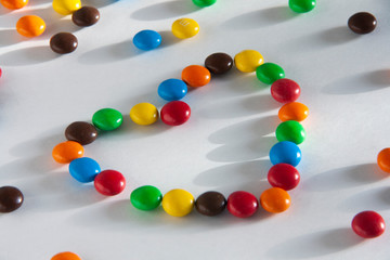 Love and Valentines Day concept.Multicolored chocolate dragees are laid out in the shape of a heart.