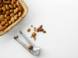 Nutcracker cracks almonds, slices of peeled almonds    on a white background      