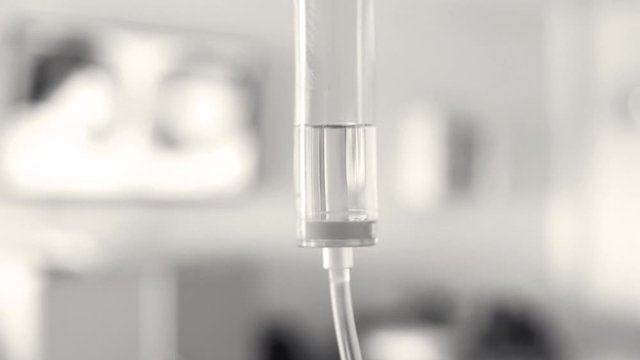 Close-up of Saline solution drip for patient and infusion pump on blurred luxury VIP room background in hospital.