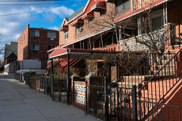Fototapeta na wymiar Row of Brick Homes along the Sidewalk in Woodside Queens New York