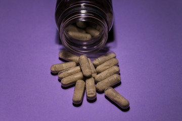Heap of pills bottle with medicine on purple background. Heap of pills, medicine for concept design. Macro closeup.