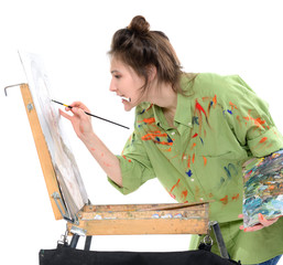Attractive teen girl painter drawing portrait with oil paints, professional painter at work over...