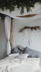 Modern home interior design. Cozy bed with wooden canopy and pillows, blanket. Bedroom interior, scandinavian style. 