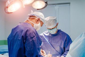 Medical team performing operation. Group of surgeon at work in operating theatre