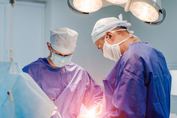 In surgery. Medical team performing operation in hospital operating theater. Working with surgical...