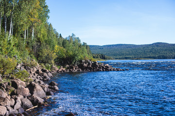 View of Kalix river, Kalixalven, Overkalix locality and the seat in Norrbotten county, Sweden, with forest in sunny summer day, aerial drone view