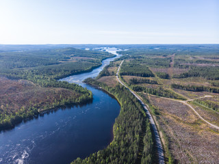Fototapeta na wymiar View of Kalix river, Kalixalven, Overkalix locality and the seat in Norrbotten county, Sweden, with forest in sunny summer day, aerial drone view