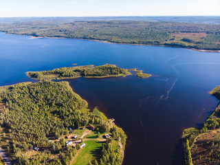 View of Kalix river, Kalixalven, Overkalix locality and the seat in Norrbotten county, Sweden, with forest in sunny summer day, aerial drone view