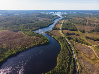 Fototapeta na wymiar View of Kalix river, Kalixalven, Overkalix locality and the seat in Norrbotten county, Sweden, with forest in sunny summer day, aerial drone view