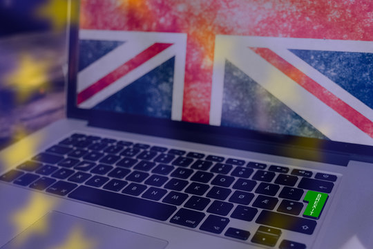 Green button on computer for brexit, union jack on the screen and the stars from the EU flag as transparent overlay