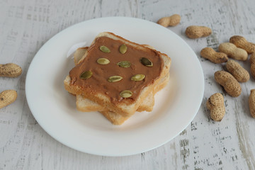Toast with peanut paste on a white background