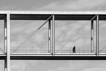 Low Angle View Of Man Walking On Bridge Against Sky In City