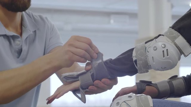 Close up of unrecognizable man putting protecting gear on female hand