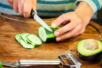 woman cuts a decorated zucchini into small slices