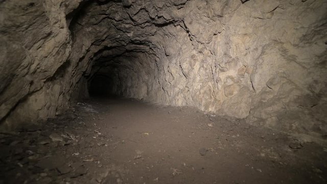 Speleology artificial cave dark tunnel excavation underground. Old adit for the extraction of metal and rocks