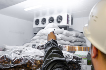 The repairman in overalls and a protective helmet carries out diagnostics of the warehouse air conditioning system. professional repair of the ventilation system