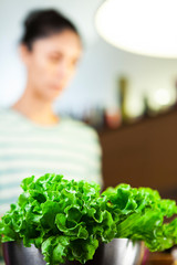 Fresh raw green lettuce and woman on the background