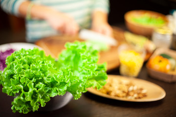 Woman prepares a vegetarian recipe with salad, corn, dried fruit and cheese