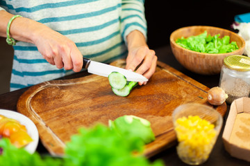 Woman cutting a courgette on the kitchen cutting board