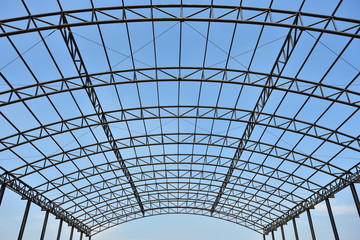 steel structure roof truss under the factory of building at construction site with blue sky