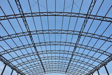 steel structure roof truss under the factory of building at construction site with blue sky