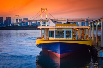 Japan. Tourist ferry on Odaiba Island. Motor ship on the background of the evening rainbow bridge...