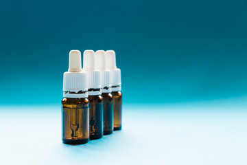cosmetology, glass bottles with pipettes and cosmetic on a blue background
