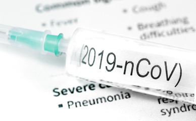 Obraz premium Novel coronavirus (2019-nCoV). Syringe with text (2019-nCoV) on papers background closeup, macro