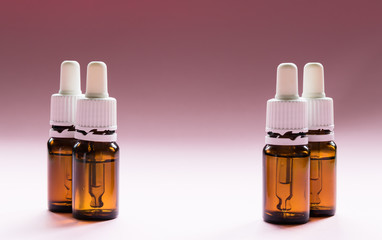 cosmetology, glass bottles with pipettes and cosmetic on a pink background