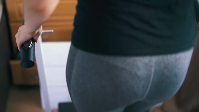 CU: active woman in tight gray leggings has intensive training on treadmill in light room close backside view