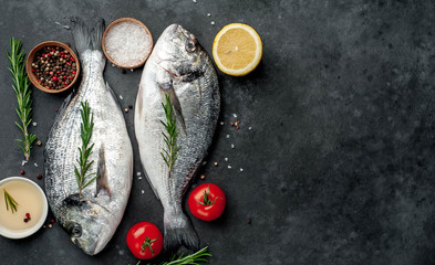 Fresh dorado fish with spices and ingredients tomato, razmorin, sunflower oil, lemon for cooking on...