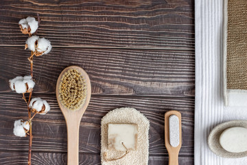 Bath and spa accessories with a cotton branch and handmade soap, on a wooden table, top view