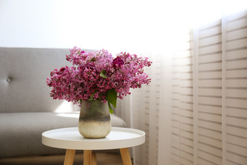 Flower vases sitting inside of window - blooming shrubbery and spring scenery outside of window.